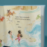 Picture book standing and open to a page showing illustration of children playing on a beach